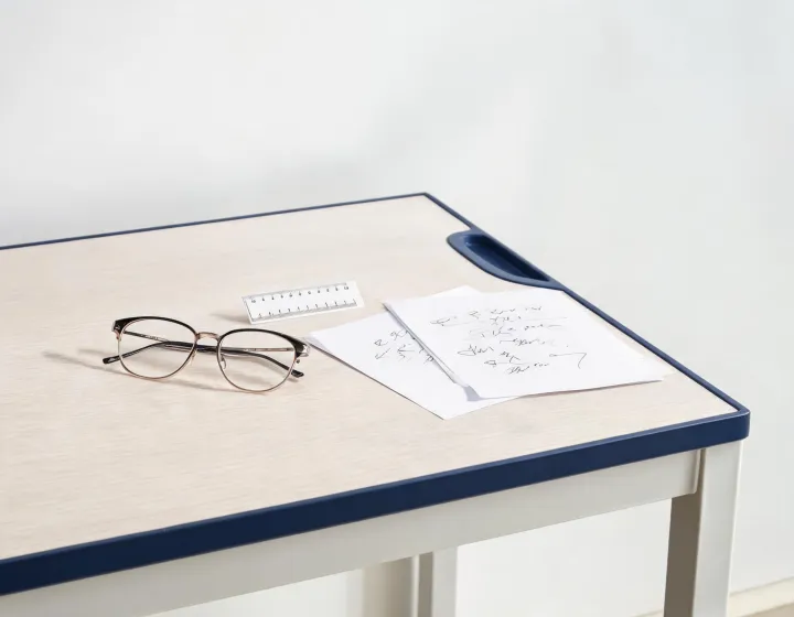 Women's computer glasses frames beside a millimetre sizing card on a sourcing desk